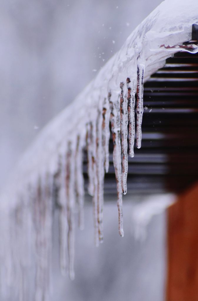 Close-up of icicles hanging from a roof in freezing winter conditions.